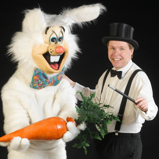 En tryllekunster og en person klædt ud som en stor kanin.